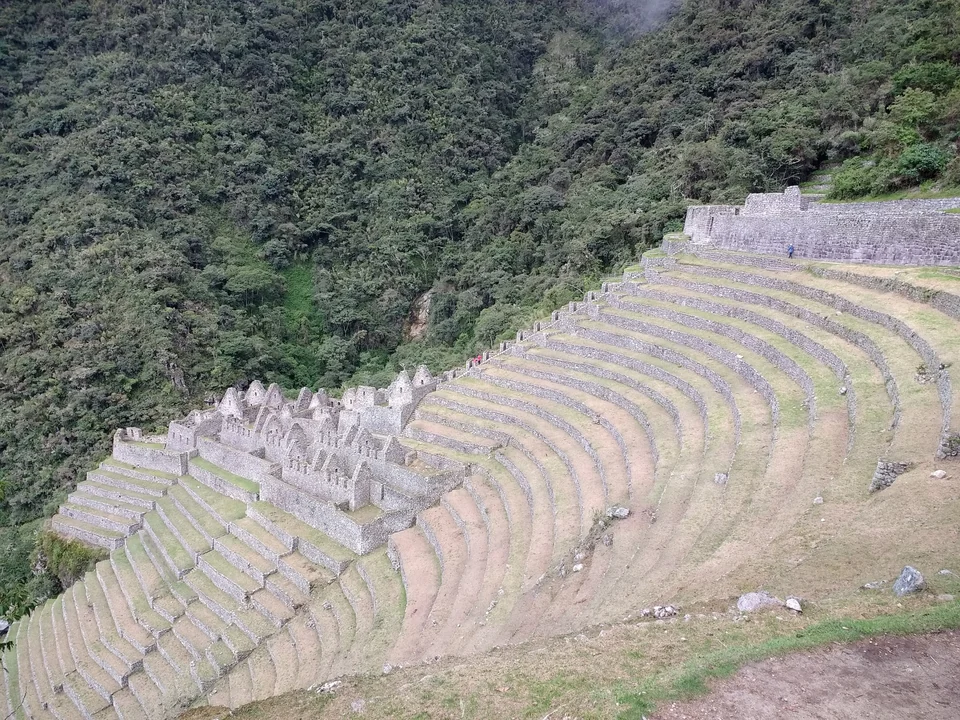 Curved stone terraces and ruins of Wiñay Wayna on a forested mountainside along the Inca Trail, Peru