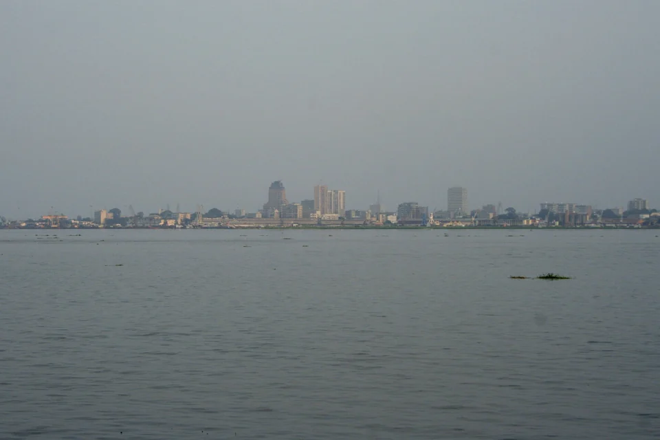 The skyline of Kinshasa seen across the wide Pool Malebo from Brazzaville on a hazy day