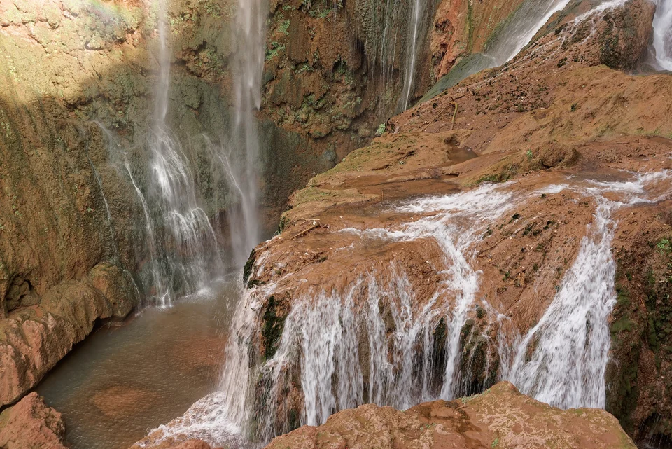 Water cascading over red travertine ledges at Ouzoud Falls in Morocco’s Middle Atlas