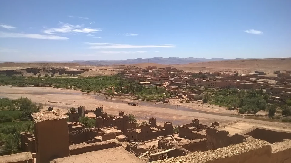 View over the Ounila Valley and river from the top of the Aït Benhaddou ksar, with earthen towers in the foreground