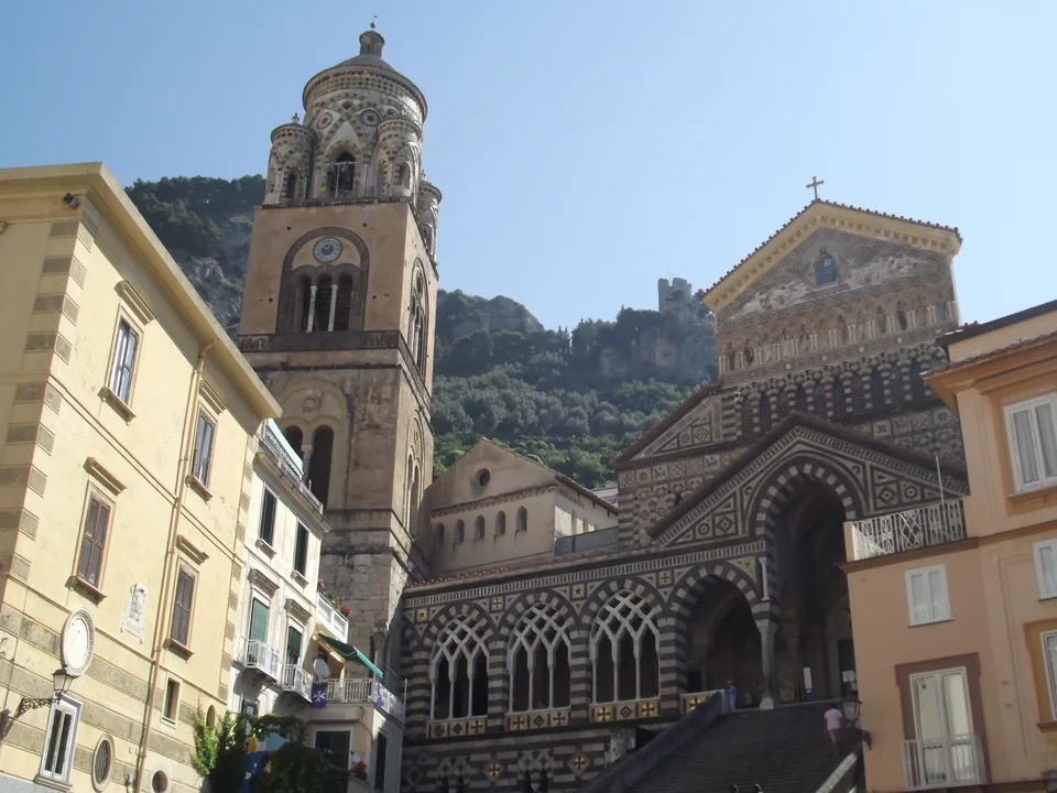Die gestreifte Fassade und der majolikagekrönte Glockenturm des Doms von Amalfi an der Piazza del Duomo, Italien