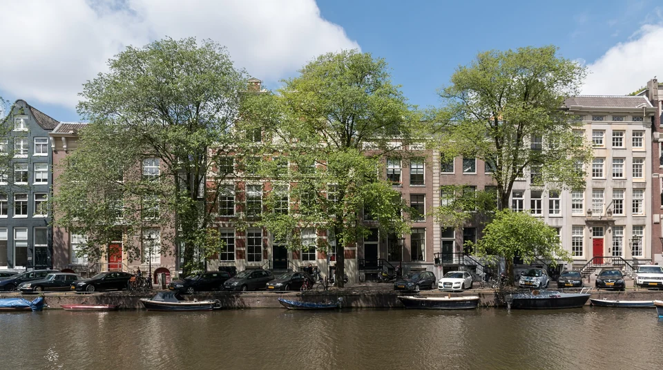 Historische Giebelhäuser spiegeln sich in der Singel im Zentrum von Amsterdam