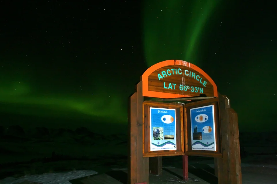 Aurora borealis over snow-covered tundra at the Arctic Circle on the Dempster Highway in Yukon
