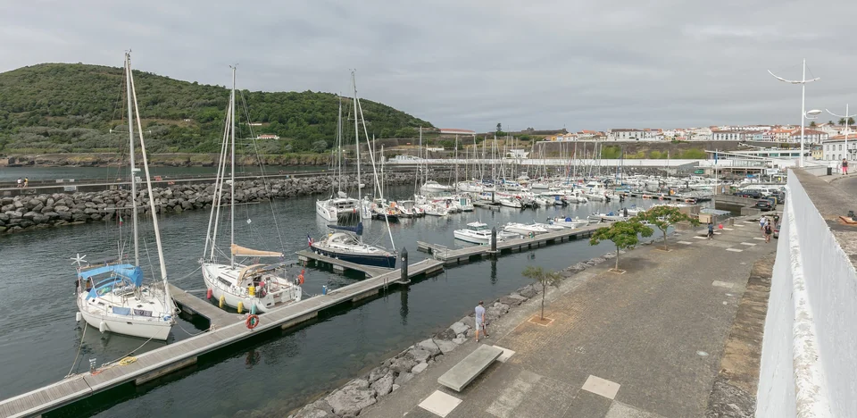 Sailboats moored in the marina of Angra do Heroísmo on Terceira, with Monte Brasil and the old town behind