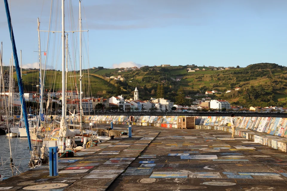 Sailboats moored at Horta Marina on Faial island, Azores, beside harbor walls covered in sailors' paintings