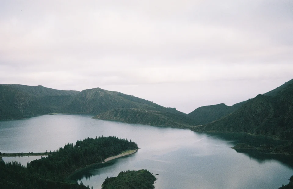 Lagoa do Fogo crater lake on São Miguel, Azores, surrounded by steep green slopes under a partly cloudy sky