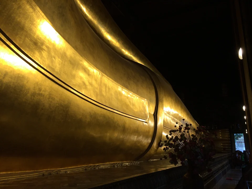 Der vergoldete Liegende Buddha im Wat Pho in Bangkok, auf der Seite liegend in einer langen Halle