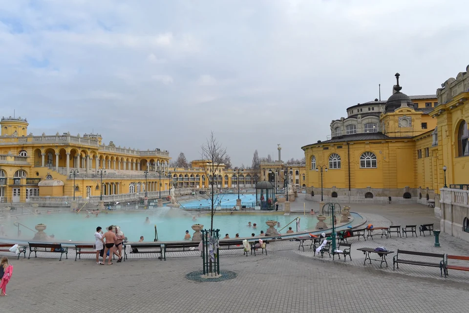 Badende in den dampfenden Außenbecken des Széchenyi-Thermalbads unter der gelben neubarocken Fassade in Budapest