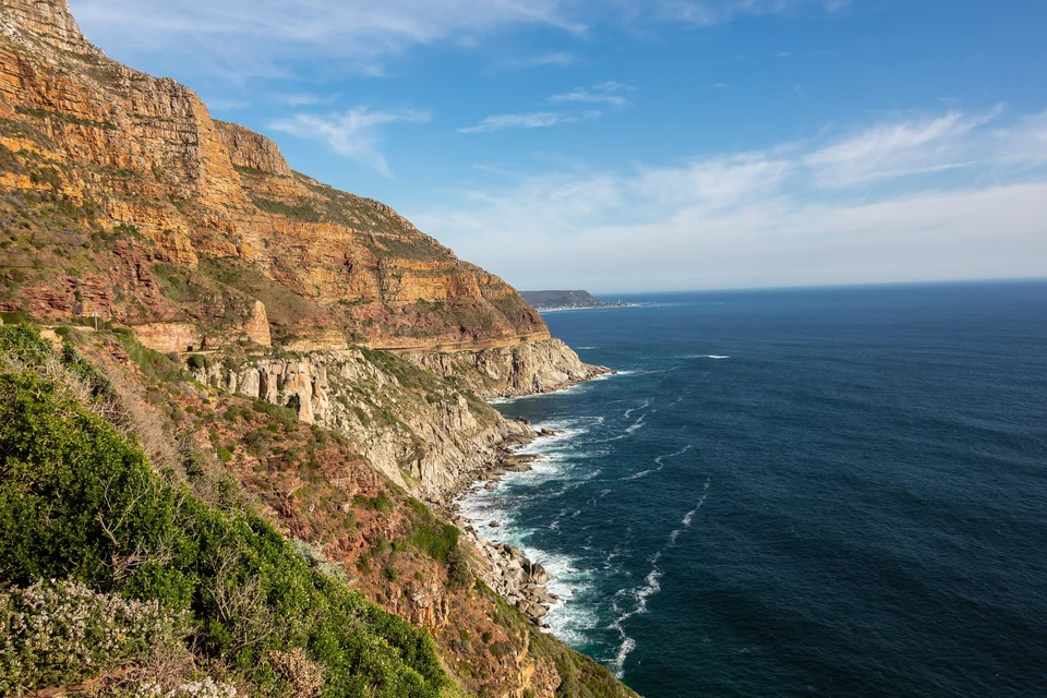 Chapman's Peak Drive cutting along orange sandstone cliffs above the Atlantic Ocean near Cape Town