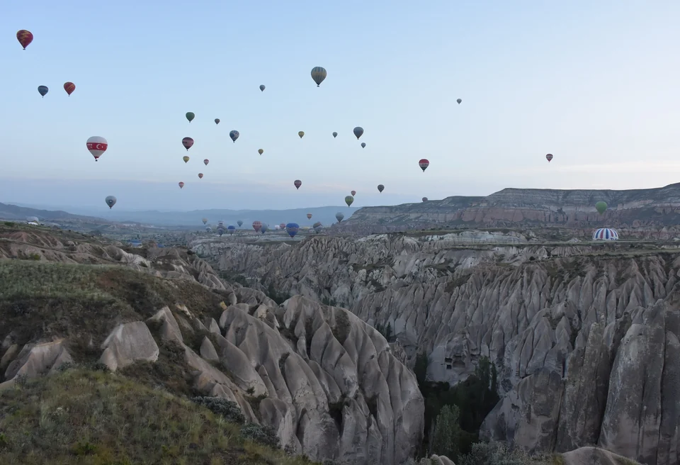 Hot air balloons drifting over the rock valleys near Göreme in Cappadocia at dawn