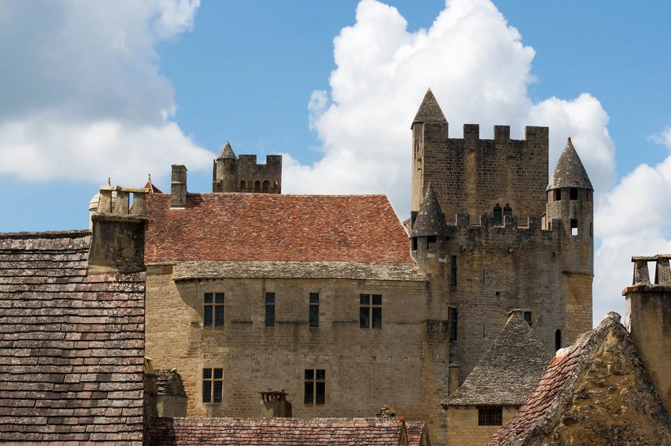 Medieval Château de Beynac with square towers and stone roofs rising above the village in the Dordogne