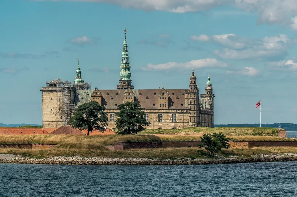 Kronborg Castle's sandstone towers and green copper spire above its ramparts at the water's edge in Helsingør