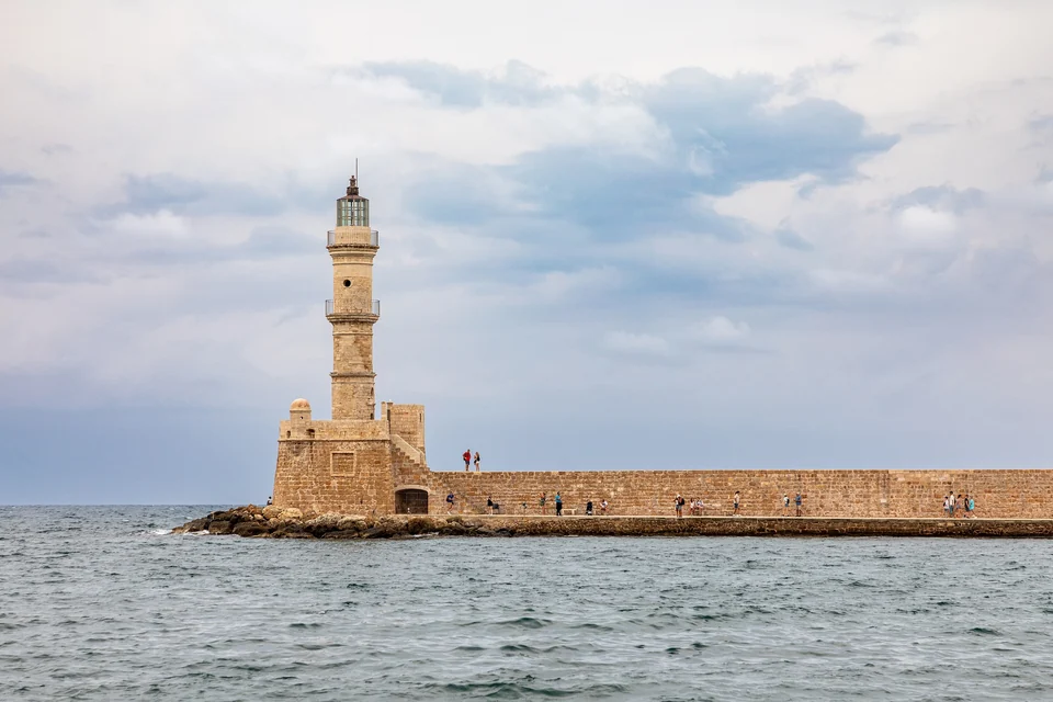 Chanias alter venezianischer Hafen mit seinem steinernen Leuchtturm und den Gebäuden an der Uferpromenade auf Kreta