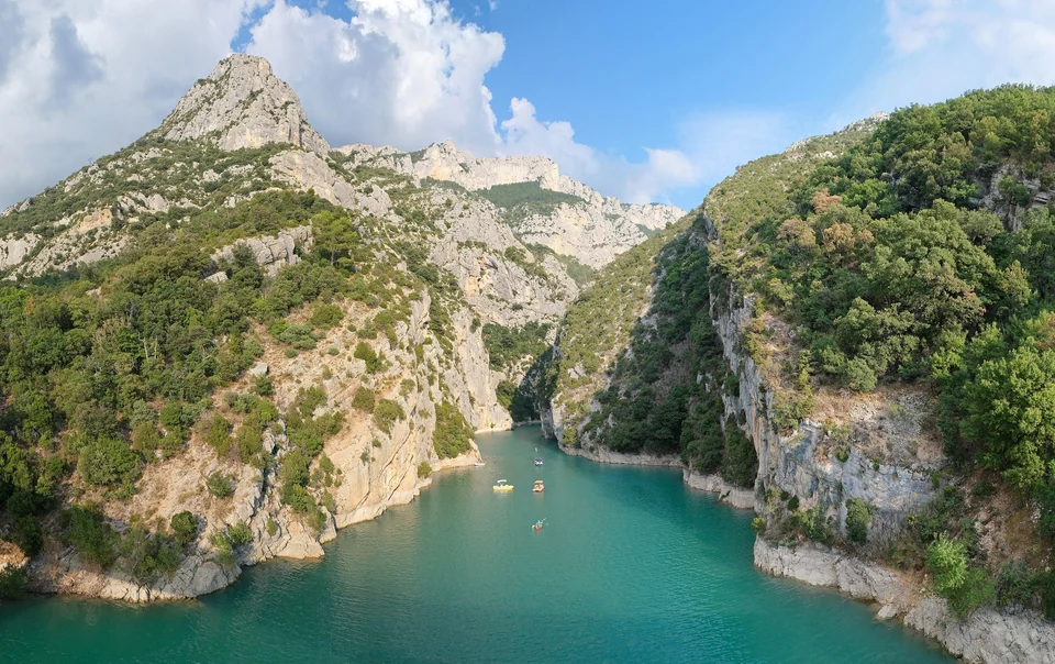 Turquoise Verdon River flowing between steep limestone cliffs at the mouth of the Verdon Gorge in Provence