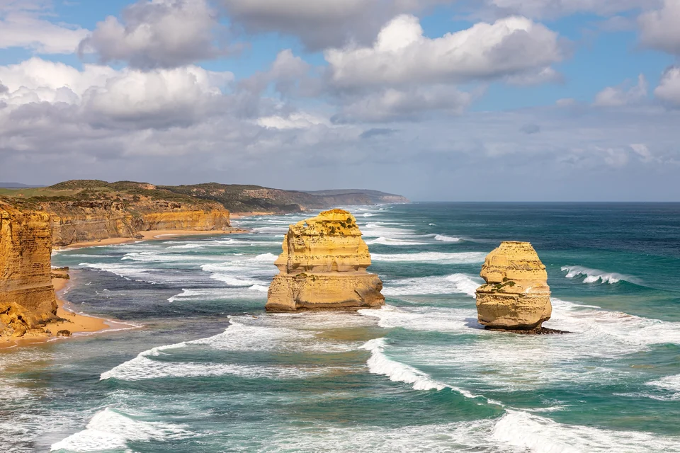 Limestone stacks of the Twelve Apostles rising from white surf below cliffs in Port Campbell National Park, Victoria