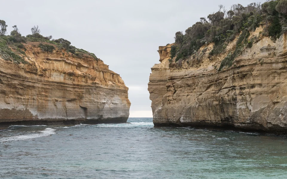 Sheer golden limestone cliffs framing the narrow sea entrance of Loch Ard Gorge on the Great Ocean Road, Victoria