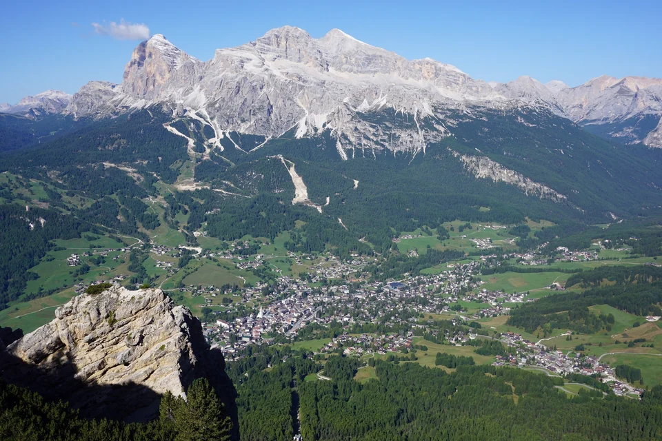 Cortina d'Ampezzo in its mountain bowl seen from Faloria with the Tofane peaks and ski slopes beyond