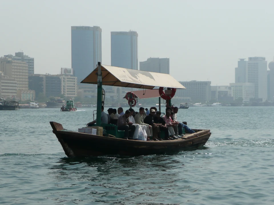 Wooden abra water taxi full of passengers crossing Dubai Creek toward the Deira waterfront