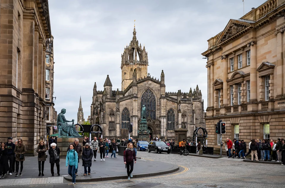 Looking down the Royal Mile in Edinburgh's Old Town with tall stone buildings and visitors on the street