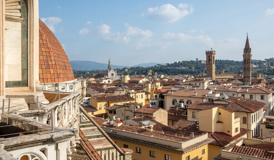 Red-tiled rooftops of Florence seen from the cathedral terrace, with the dome and the tower of Palazzo Vecchio
