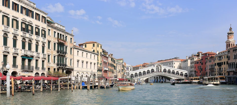 Gondolas and boats on the Grand Canal in Venice with the Rialto Bridge and historic palazzi