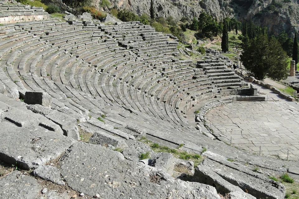 Ancient Greek theater of Delphi on the slopes of Mount Parnassus with mountains in the background