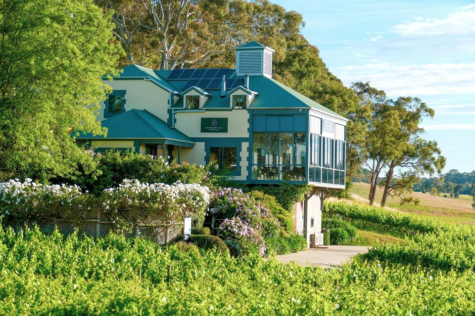Winery building surrounded by vines and flowering gardens in the green Adelaide Hills near Hahndorf