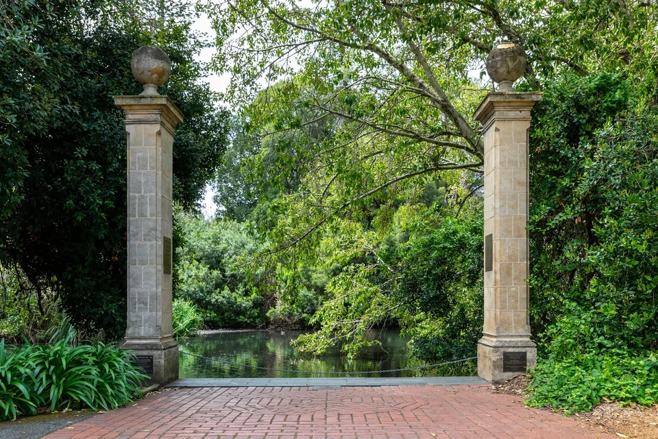 Stone gateposts framing a leafy pond in the Adelaide Botanic Garden, South Australia