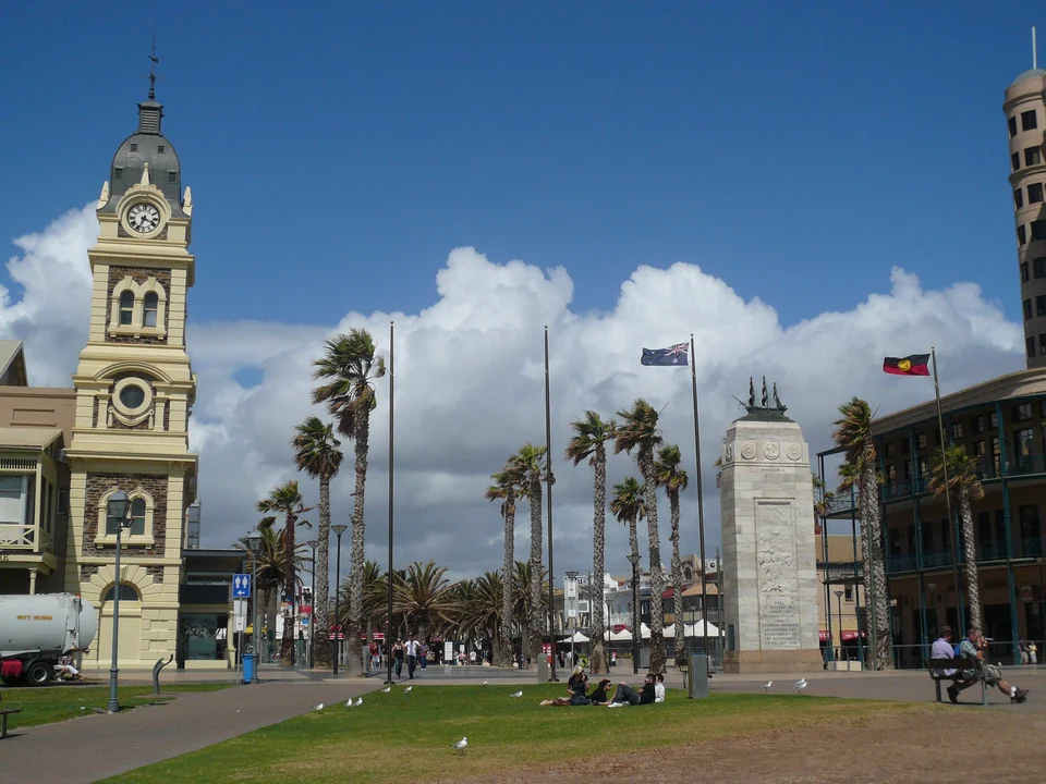 Moseley Square in Glenelg with the town hall clock tower, palm trees and the pioneer memorial near the beach