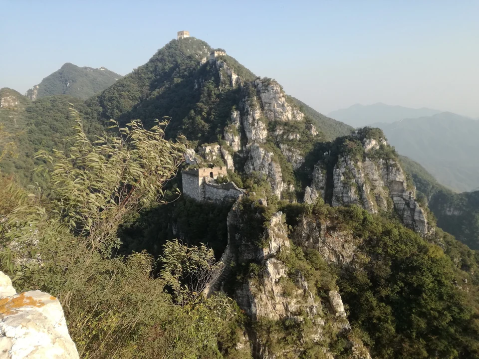 Unrestored Ming Great Wall climbing a steep forested ridge at Jiankou north of Beijing