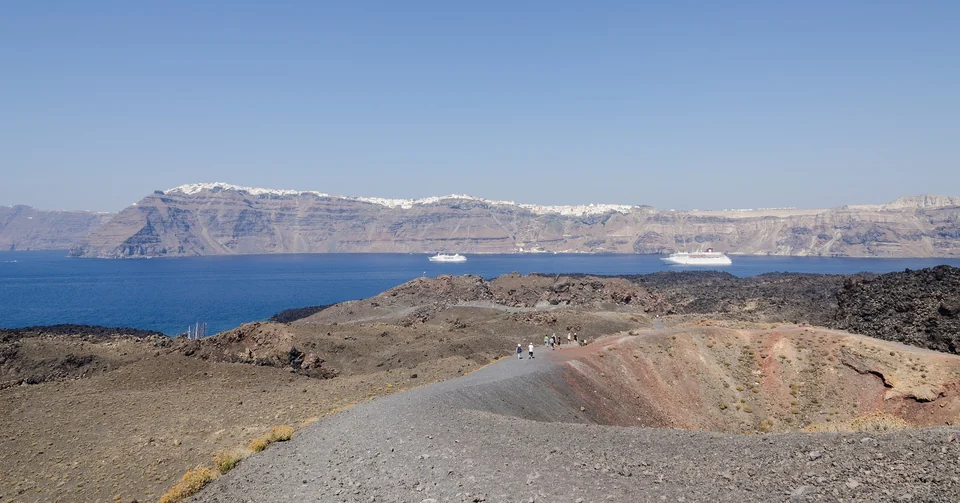 Dark lava fields and hiking paths on Nea Kameni volcanic island in the Santorini caldera