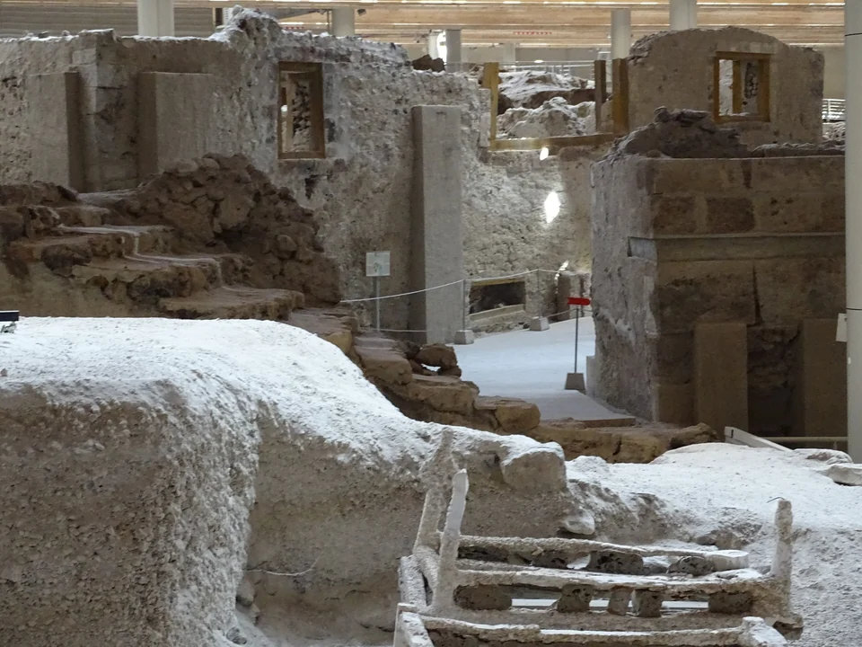 Excavated Bronze Age stone buildings and stairs under the protective roof at the Akrotiri archaeological site, Santorini