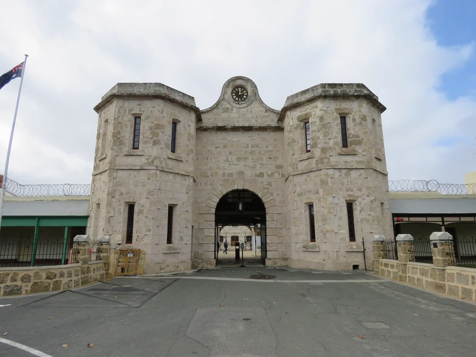 Limestone gatehouse with a clock and arched entrance at the UNESCO-listed Fremantle Prison, Western Australia