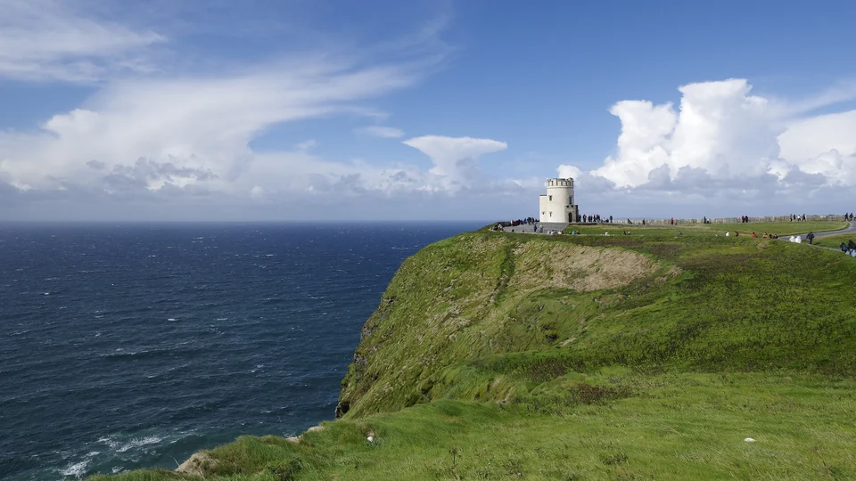 Layered sea cliffs and the round stone O'Brien's Tower at the Cliffs of Moher on the Clare coast