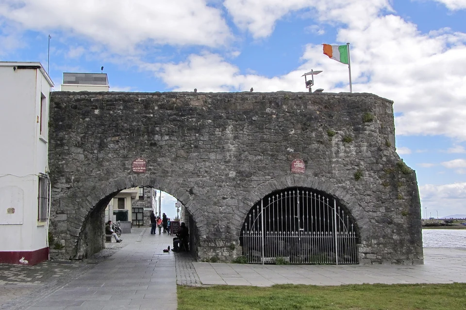 Stone Spanish Arch beside the river in Galway with a pedestrian walkway in front