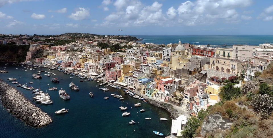 Pastellfarbene Häuser und Fischerboote am Hafen von Marina Corricella auf Procida