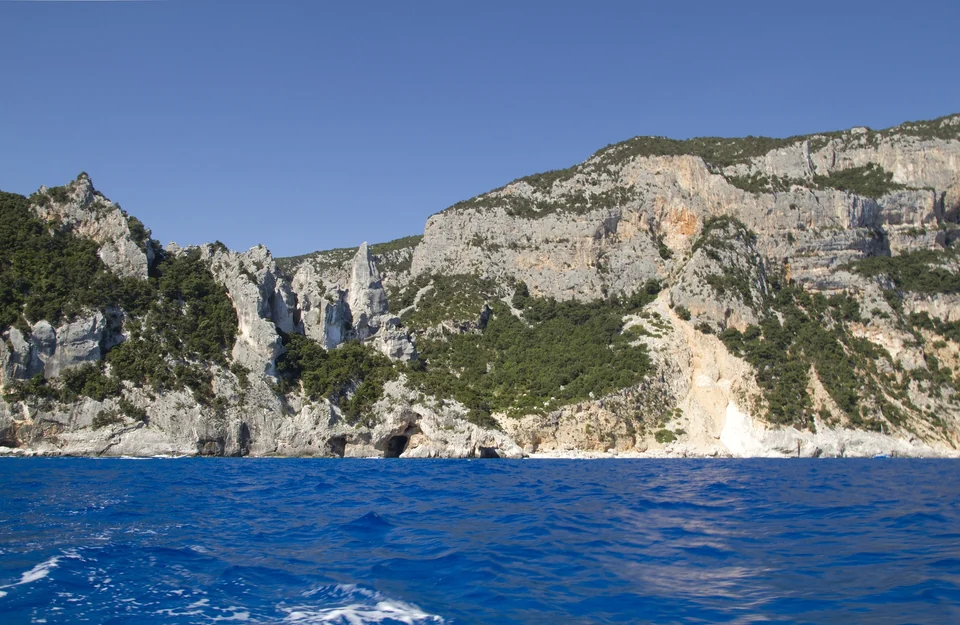 Kalksteinklippen und der Felsturm über der Cala Goloritzé am Golf von Orosei auf Sardinien, von einem Boot aus gesehen