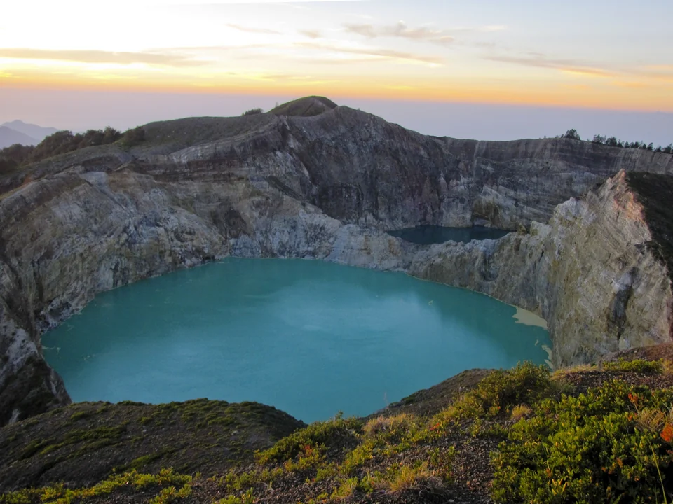 Die Kraterseen des Kelimutu im ersten Licht mit Kraterrand und umliegenden Hügeln, Flores