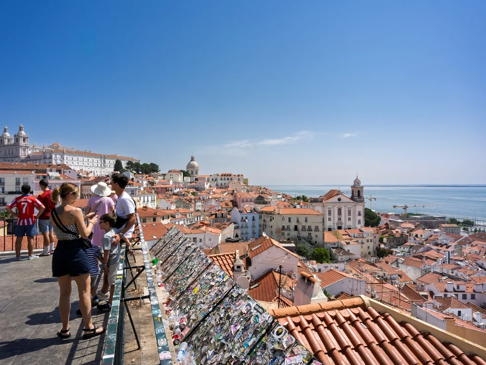 View from Miradouro de Santa Luzia over the red rooftops of Alfama and the Tagus River in Lisbon