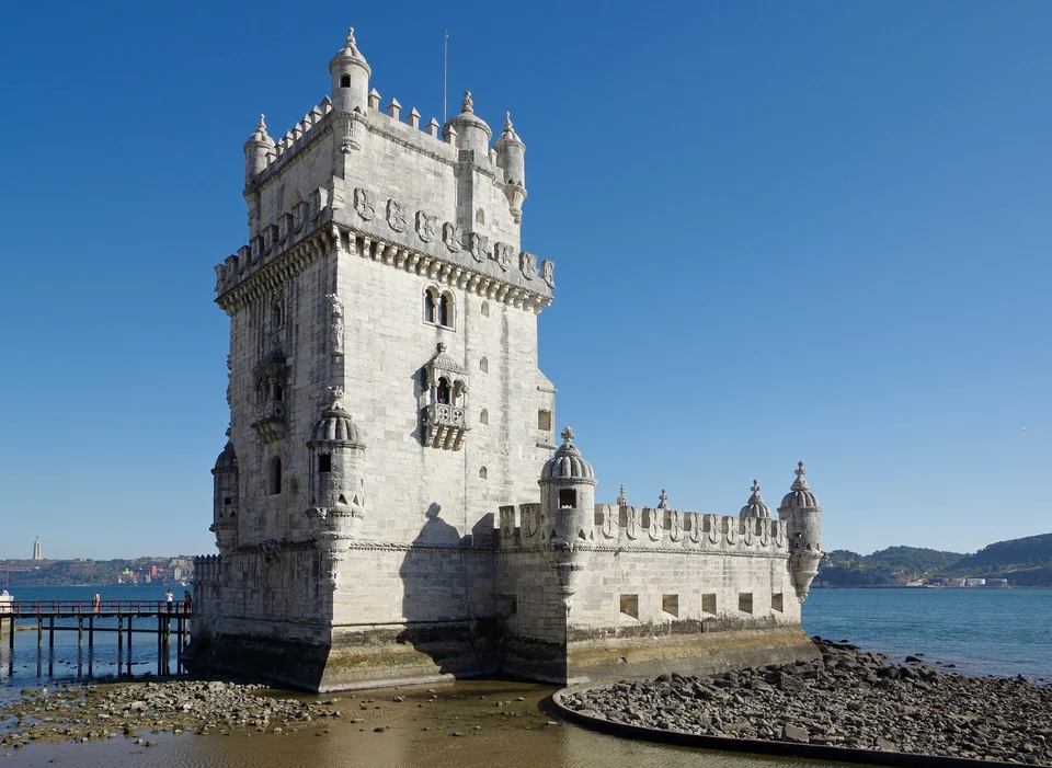 The white stone Belém Tower with its carved balconies and battlements on the Tagus riverbank in Lisbon