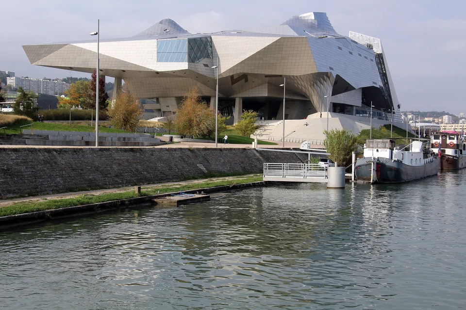 Angular steel and glass Musée des Confluences building on the riverbank in Lyon with moored barges