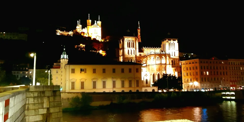 Fourvière basilica lit up on its hill above Saint-Jean Cathedral and the Saône River in Lyon at night