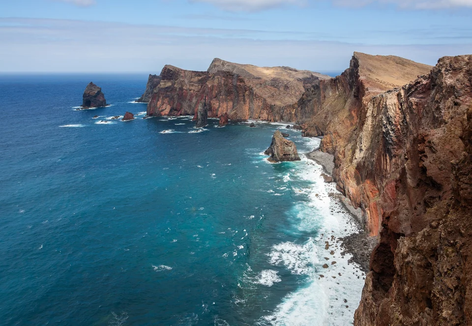 Red and ochre sea cliffs and rock stacks along the Ponta de São Lourenço peninsula on Madeira's east coast