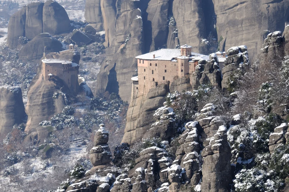 Les monastères de Roussanou et de Saint-Nicolas Anapausas sur des piliers rocheux saupoudrés de neige, aux Météores, en Grèce