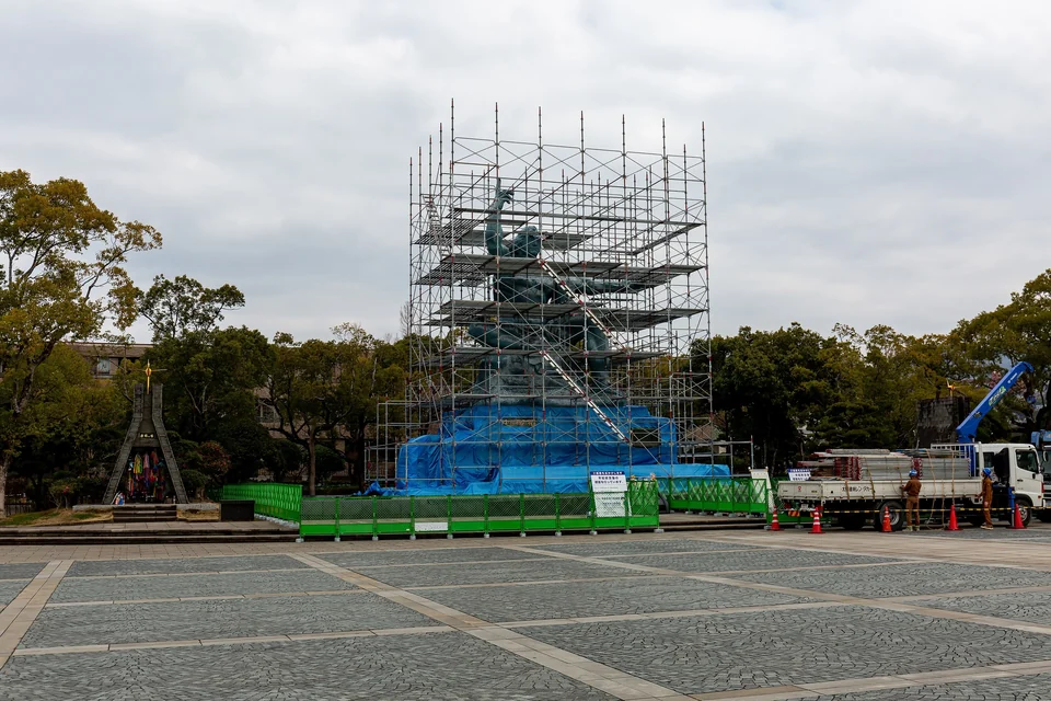 La statue blanche de la Paix, assise et un bras levé, dans le parc de la Paix de Nagasaki