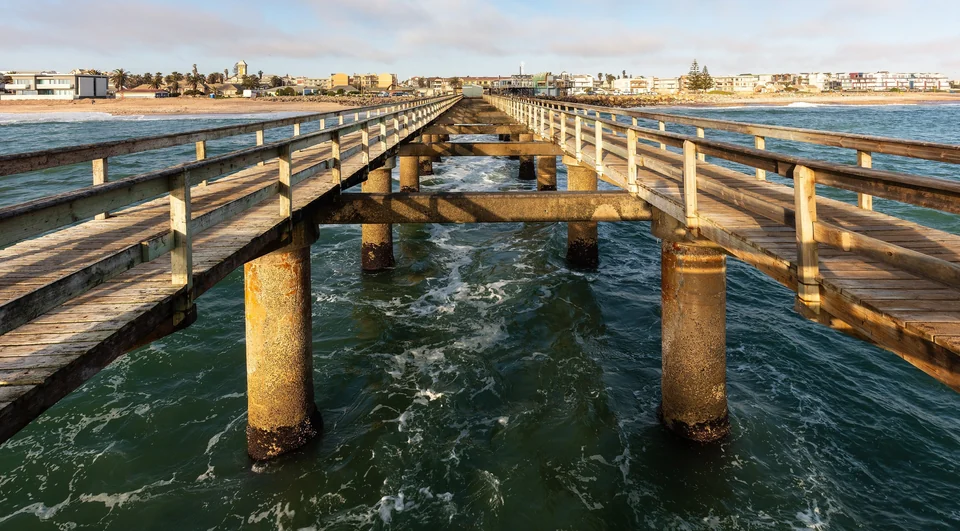 Long jetty extending into the Atlantic Ocean at Swakopmund, Namibia, with the town on the shore