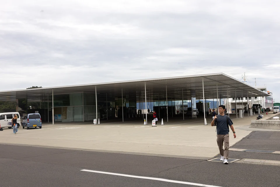 Terminal de ferry ouvert à toit plat du port de Miyanoura, à Naoshima, avec un ferry à quai à côté