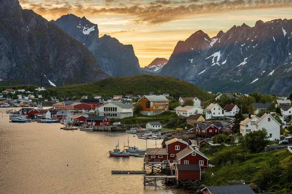 Rote Fischerhütten und Häuser am Wasser im Dorf Reine auf den Lofoten, Norwegen