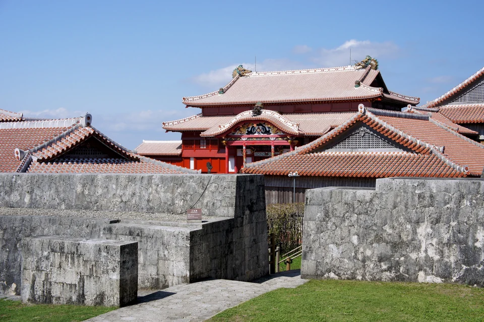 Red-lacquered Seiden main hall of Shuri Castle in Naha behind gray limestone walls and red tile roofs