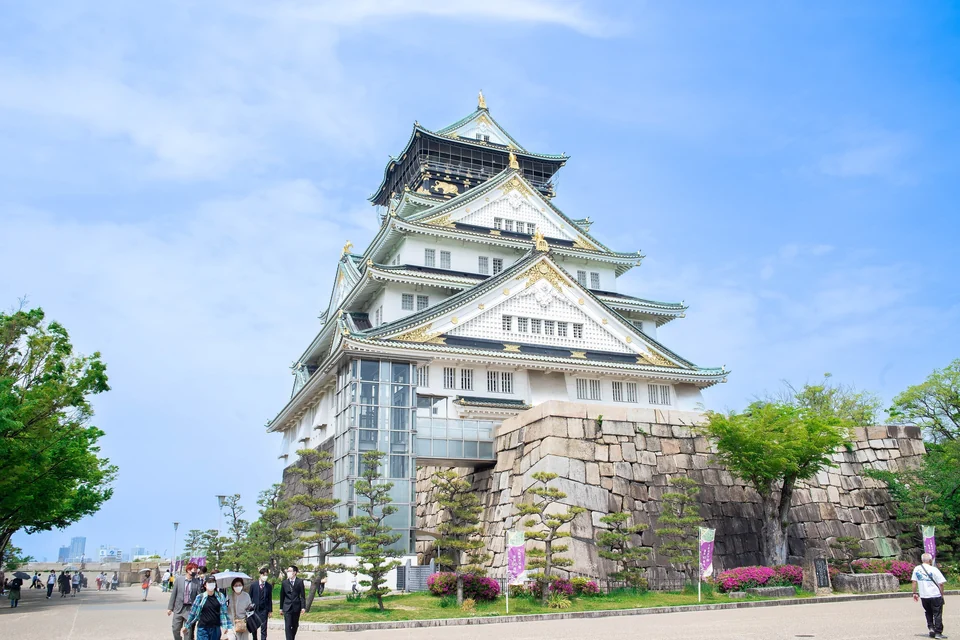 Osaka Castle main keep with green roofs and stone walls rising above its moat
